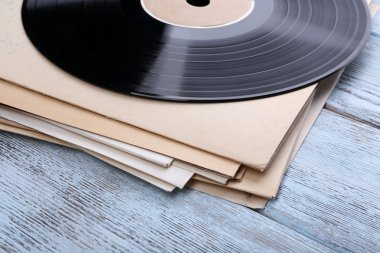 vinil kayıtları ve kağıt kapakları ahşap zemin üzerinde