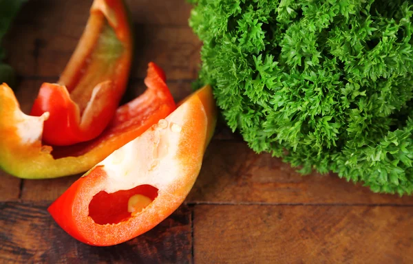 Green fresh parsley and sliced bell pepper  on wooden background — Stock Photo, Image
