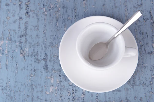 Empty cup with tea spoon on wooden background — Stock Photo, Image