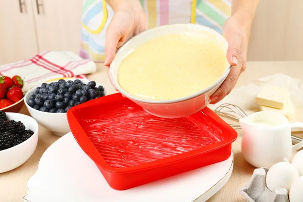 Hornear sabroso pastel e ingredientes para ello en la mesa en la cocina —  Fotos de Stock