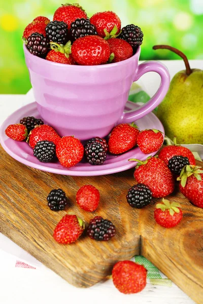 Berries in bowl with pears on table on bright background — Stock Photo, Image