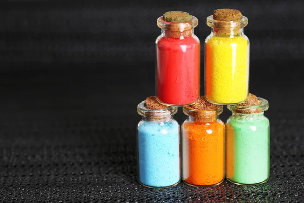 Garrafas com pigmentos secos coloridos no fundo escuro — Fotografia de Stock