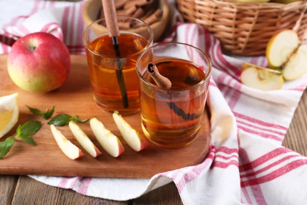 Stilleben med äppelcider och färska äpplen på träbord — Stockfoto