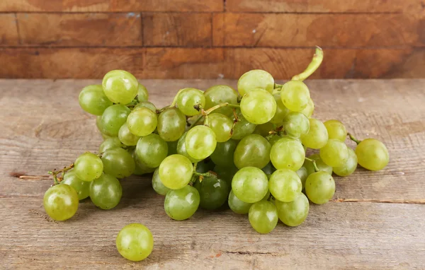 Raisin vert sur table en bois sur fond en bois — Photo