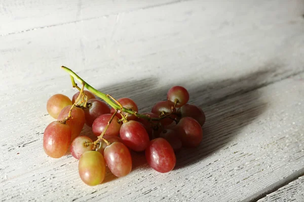 Pink grape on wooden table on wooden background — Stock Photo, Image