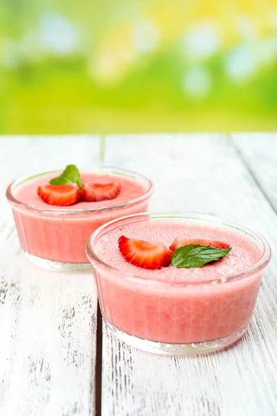 Deliciosa mousse de bayas en cuencos en la mesa sobre fondo brillante — Foto de Stock