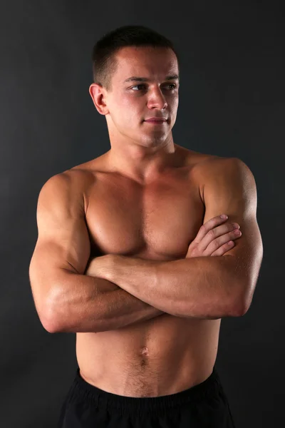 Hezký svalů mladý muž na tmavém pozadí — Stock fotografie