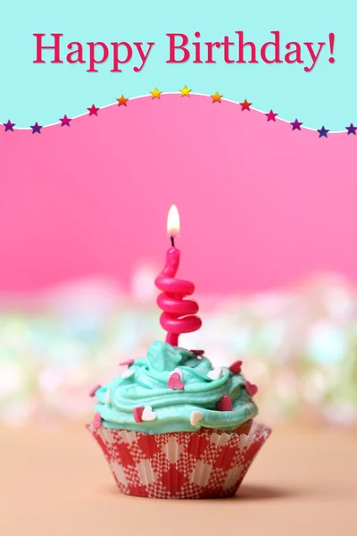 Delicioso cupcake de aniversário na mesa no fundo rosa — Fotografia de Stock