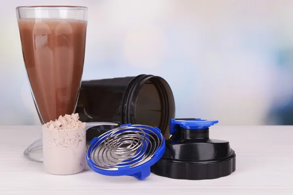 Whey protein powder with shake and plastic shaker on table on bright background — Stock Photo, Image