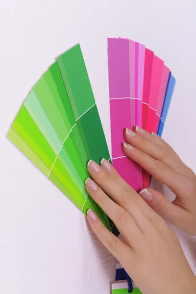 Woman choosing color for wall from swatches in room — Stock Photo, Image