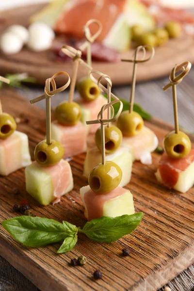 Delicious melon with prosciutto on table close-up — Stock Photo, Image