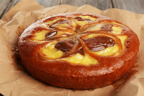 Delicioso pastel con caramelo sobre papel en la mesa de cerca — Foto de Stock