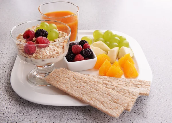 Segmenten van vruchten met bessen en muesli op tafel close-up — Stockfoto