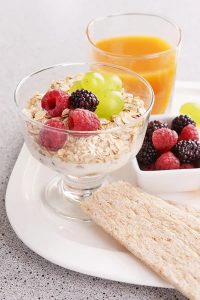 Slices of fruits with berries and muesli on table close up — Stock Photo, Image