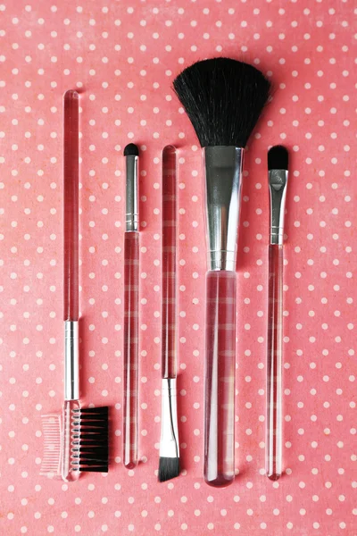 Cepillos para maquillaje sobre fondo rosa — Foto de Stock