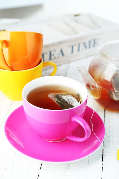 Чашку з чаєм, чайник і чай у пакетиках на дерев'яну столову Закри — стокове фото