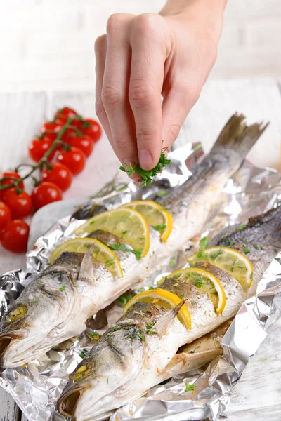 Sabroso pescado al horno en papel de aluminio en primer plano de la mesa — Foto de Stock