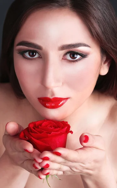 Chica con labios rojos, uñas y rosa de cerca — Foto de Stock