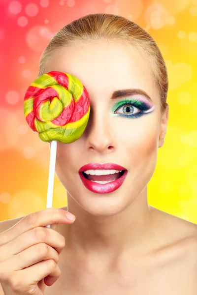 Beautiful woman with colorful lollipop on bright background — Stock Photo, Image