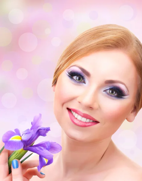 Vacker ung kvinna med glamour make up och blomma ob ljus bakgrund — Stockfoto