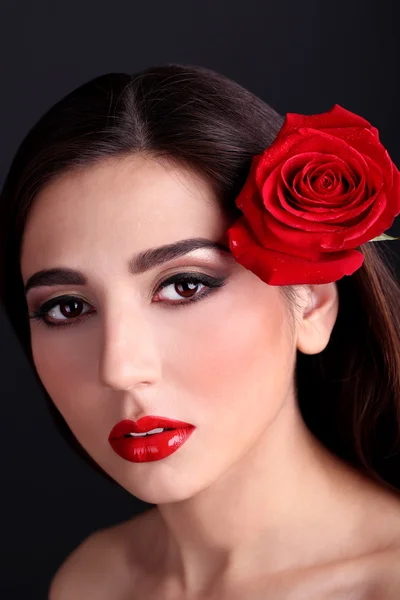 Chica con labios rojos y rosa sobre fondo oscuro — Foto de Stock