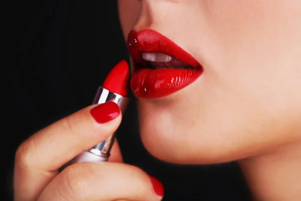 Sexy labios rojos y lápiz labial sobre fondo oscuro — Foto de Stock