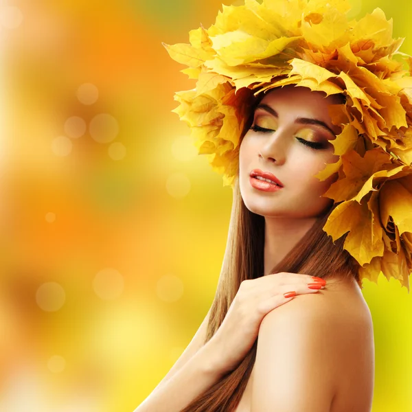 Beautiful young woman with yellow autumn wreath on bright background — Stock Photo, Image