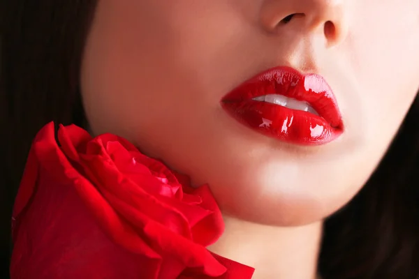 Labios rojos de mujer y rosa sobre fondo oscuro — Foto de Stock