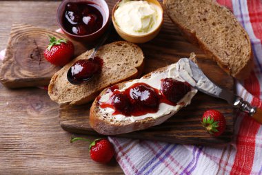 ahşap arka plan üzerinde ev yapımı tereyağı ve çilek reçel taze tost