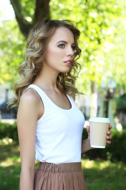 Caddenin üzerinde kahve ile güzel genç kız