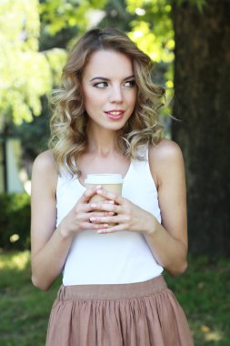 Caddenin üzerinde kahve ile güzel genç kız