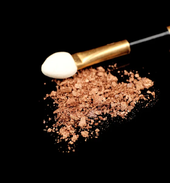 Crushed eyeshadow and professional make-up brush isolated on black — Stock Photo, Image