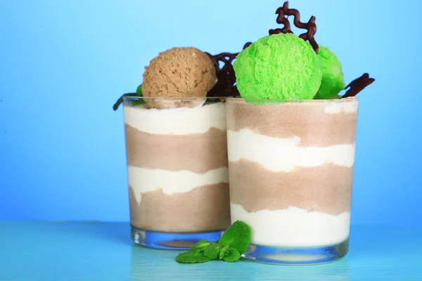Mousse de chocolate saboroso com sorvete no fundo azul — Fotografia de Stock