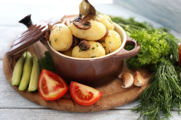 Patate bollite giovani in pentola con verdure su tavolo di legno, da vicino — Foto Stock