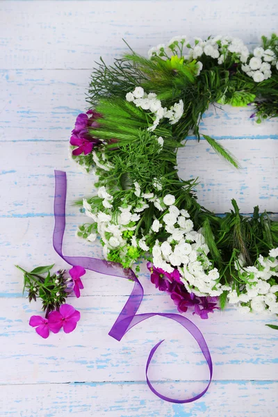 Corona de flores silvestres sobre fondo de madera gris — Foto de Stock