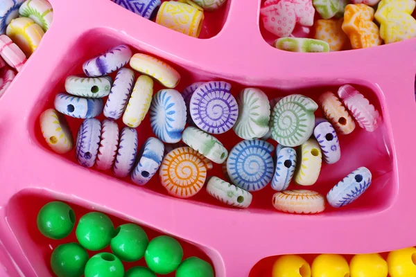 Kit beading multicolorido para crianças em uma caixa rosa — Fotografia de Stock