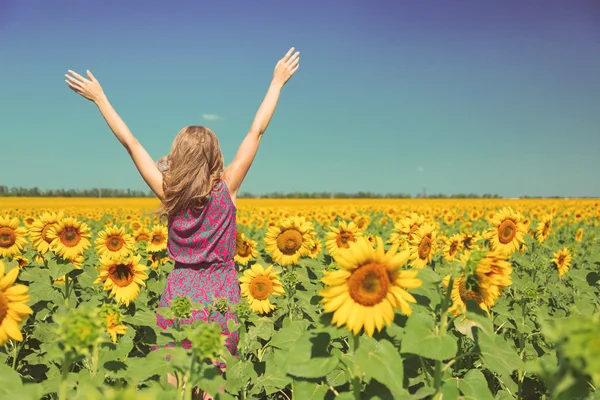 Junge Frau im Sonnenblumenfeld — Stockfoto