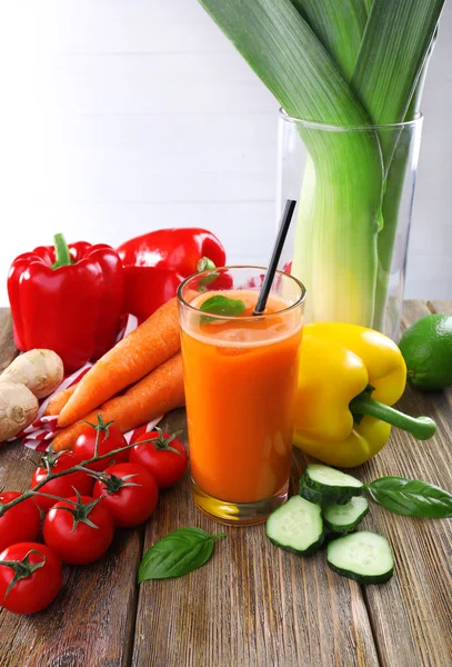 Vaso de jugo de zanahoria fresca y verduras en mesa de madera — Foto de Stock