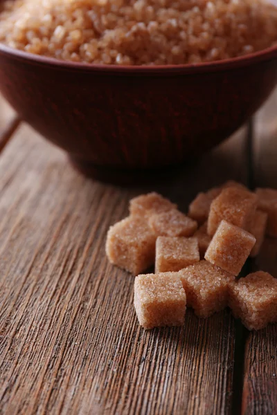 Zucchero di canna cubetti e zucchero di cristallo in ciotola su sfondo di legno — Foto Stock