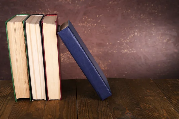 Boeken over houten tafel op donkere achtergrond — Stockfoto