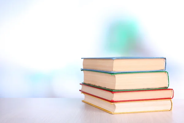 Boeken over houten tafel op natuurlijke achtergrond — Stockfoto