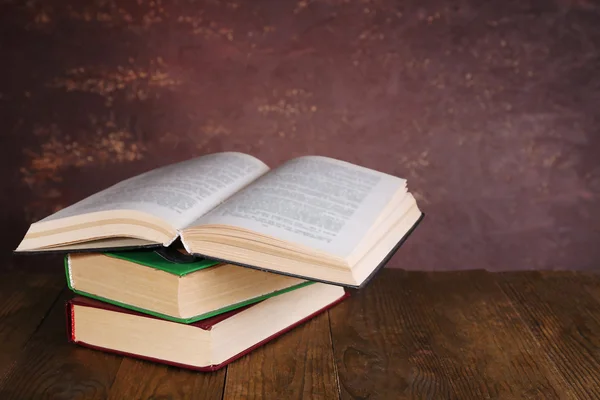 Livros sobre mesa de madeira sobre fundo escuro — Fotografia de Stock