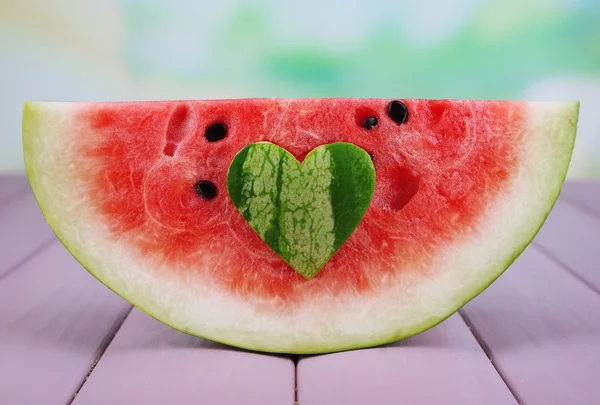 Slice of watermelon on wooden table on natural background — Stock Photo, Image