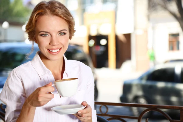 Schöne junge Frau sitzt im Café — Stockfoto