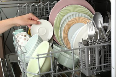 Open dishwasher with clean utensils in it clipart