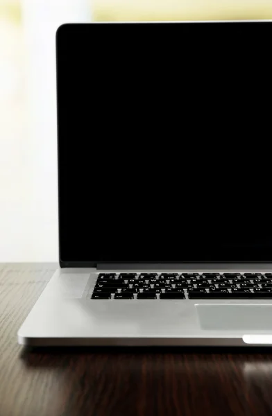 在明亮的背景上的空白屏幕的笔记本电脑 — 图库照片