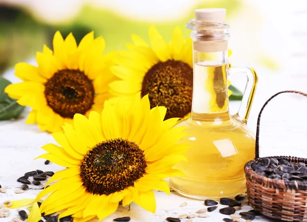 Sunflowers with seeds and oil on table close-up — Stock Photo, Image