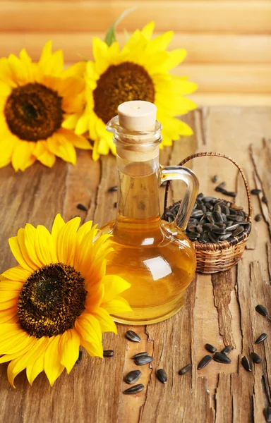 Girasoles con semillas y aceite sobre fondo de madera —  Fotos de Stock