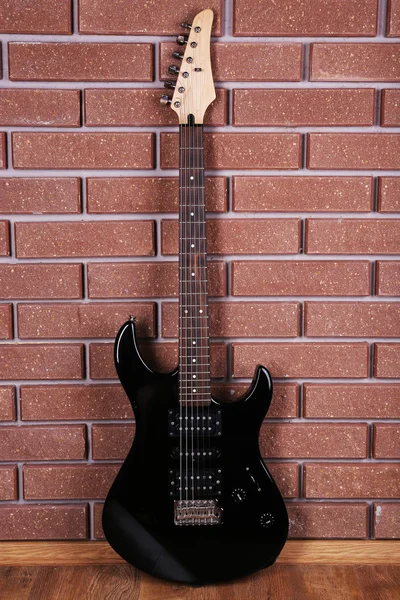 Гитара на фоне кирпичной стены — стоковое фото