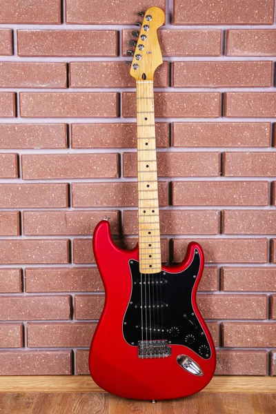 Guitarra sobre fondo de pared de ladrillo — Foto de Stock